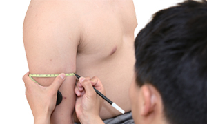 팔 앞편에 펜으로 표시를 하고있는 검사자