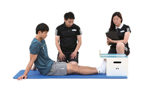 윗몸 앞으로 굽히기 검사도구에 발을 대고 앉아있는 실시자