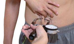 기구를 이용하여 배의 피부두께를 측정하는 검사자